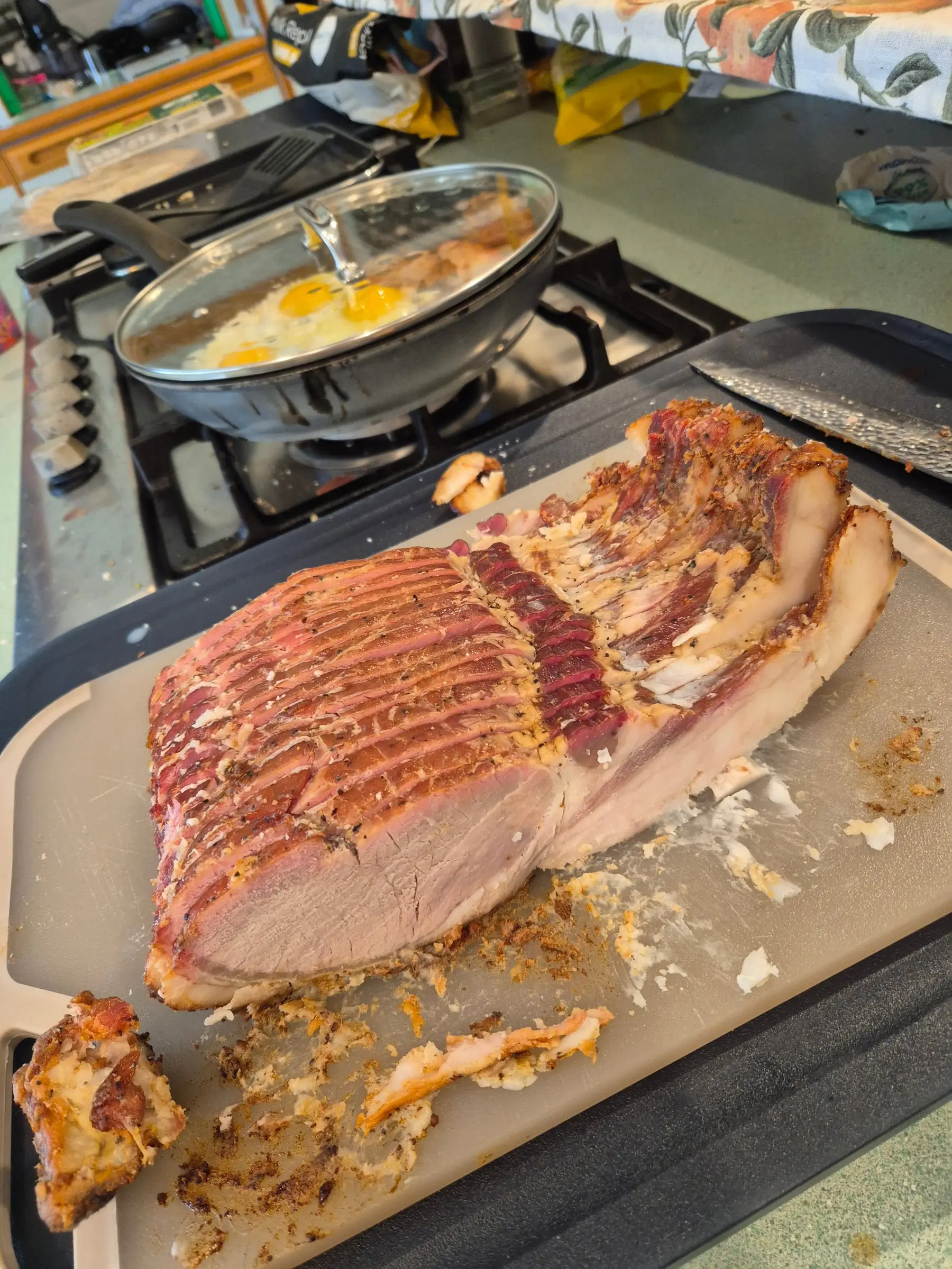 A slab of our hot-smoked bacon on the board, with the first rashers cooked beside it